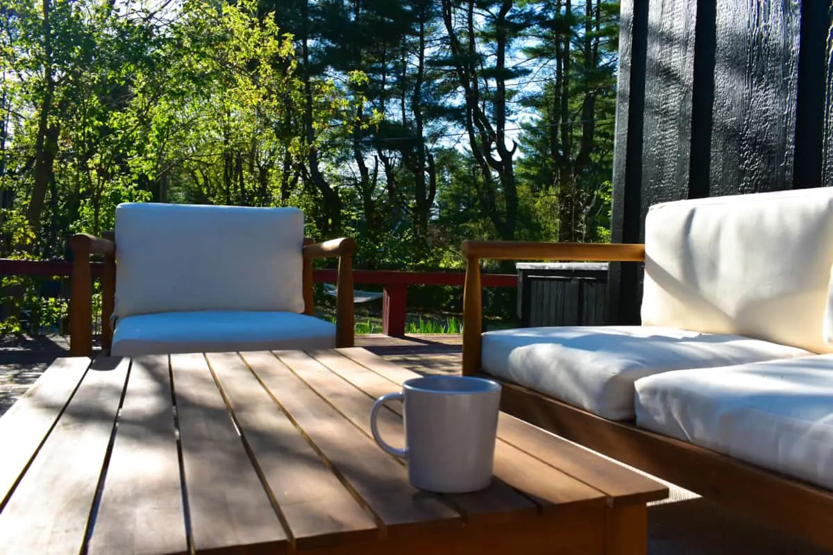 Deck with teak lounge seating under tall pines